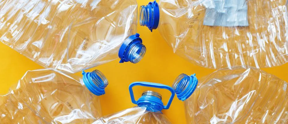 A lot of plastic empty rumpled used bottles on a yellow background. waste and 스톡 사진