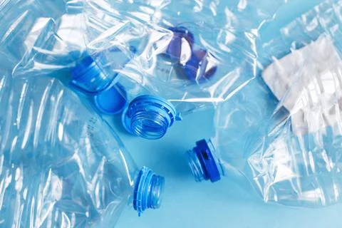 A lot of plastic empty rumpled used bottles on a blue background. waste and p Фото