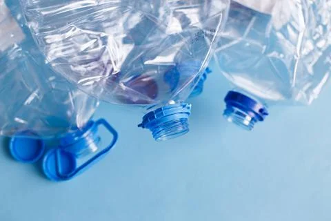 A lot of plastic empty rumpled used bottles on a blue background. waste and p Stock Photos