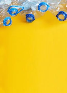 A lot of plastic empty rumpled used bottles on a yellow background. waste and 스톡 사진