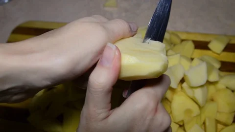 A lot of potatoes on table and on a cutting board. sliced on a cutting board. Stock Footage 98158605