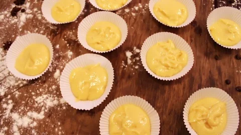 Lot of raw dough for muffins in special paper forms for baking Stock Footage