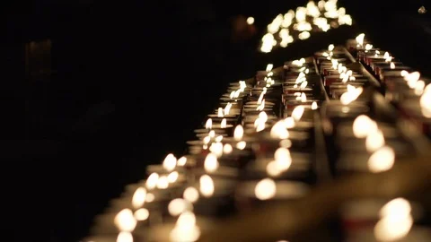 A lot of red tiny candles waving in a dark background inside a church. Stock Footage 101900402