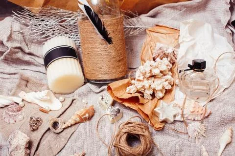 A lot of sea theme in mess like shells, candles, perfume, girl stuff on linen Stock Photos