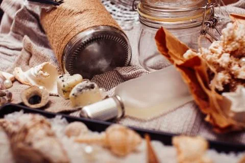 A lot of sea theme in mess like shells, candles, perfume, girl stuff on linen Stock Photos