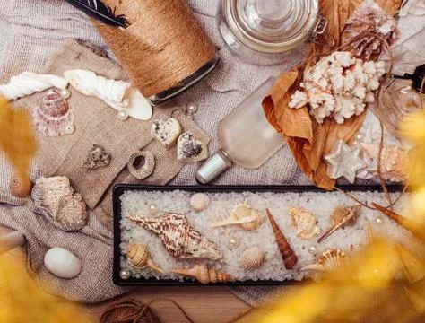 A lot of sea theme in mess like shells, candles, perfume, girl stuff on linen Stock Photos
