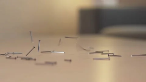Lot of silver thin small sharp nails fall on the wooden floor, slow motion. Stock Footage 220687951