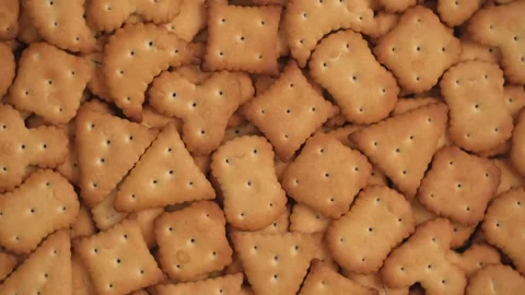 Lot of small cracker cookies of different shapes are rotating, closeup. top view Stock Footage 240107647