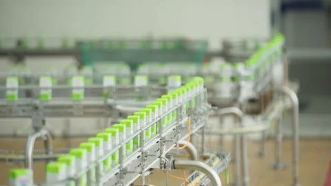 A lot of the Small Packets with Milk are Slowly Going Through the Conveyor Line. Stockbeeldmateriaal 273312420