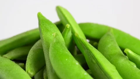 A lot of snap peas on a white background, macro, slow motion, rotation. Gro.. Stock Footage 231110410