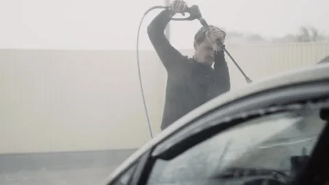 A lot of splashes above a car surface while stylish young adult man clean car Stock Footage 144676144