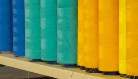 A lot of spools of colored threads on the table Stock Photos