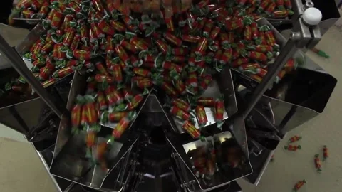 A lot of sweets end up in a packaging machine at a candy factory. Stock Footage 128643243