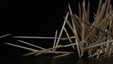 A lot of toothpicks fall down on a black background. Slow motion Video stock 75781001