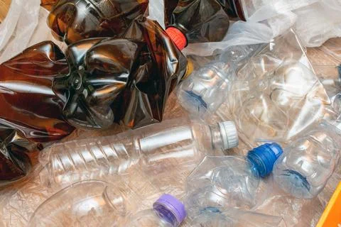 Lot of used plastic, crumpled empty bottles, packets, plastic orange dish, di Foto stock