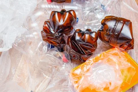 Lot of used plastic, crumpled empty bottles, packets, plastic orange dish, di Stock Photos