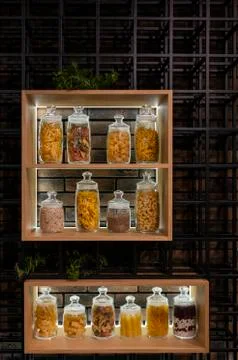 A lot of variable jars on a shelf in a modern interior with pasta, spaghetti Fotos de archivo