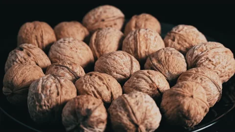 Lot of Walnuts in the Shell are Spinning on a Black Background Video stock 200732255