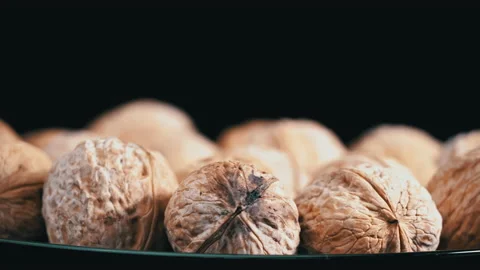 Lot of Walnuts in the Shell are Spinning on a Black Background Stock Footage 200864451