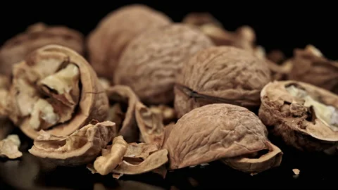 Lot of Walnuts in the Shell are Spinning on a Black Background Stock Footage 201055185