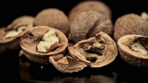 Lot of Walnuts in the Shell are Spinning on a Black Background Stock Footage 201061568