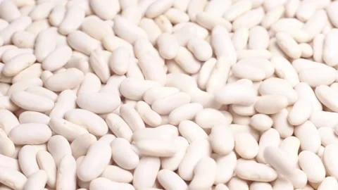 A lot of white beans lie in the background. Beans are sprinkled on top Stock Footage 232982168