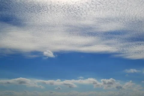 A lot of white clouds of different types high in blue sky Stock Photos