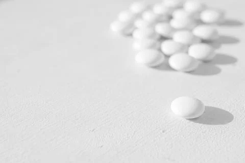 A lot of white round tablets lying on a white background. side view Stock Photos