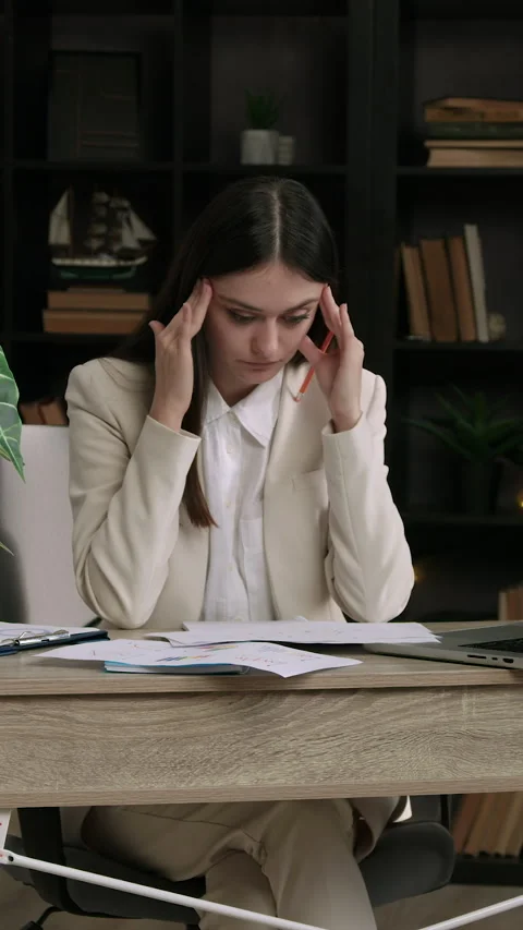 A lot of work for an important project. A brunette woman in a suit sits at an Stock Footage 305413302