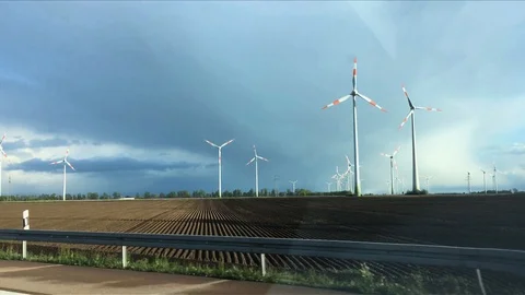 A lot of Working wind power generators on the field. View from moving car window Stock Footage 108282868