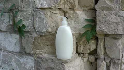 Lotion or shampoo on brick wall with leaves. Natural Organic Spa Cosmetic Stock Footage 159537206
