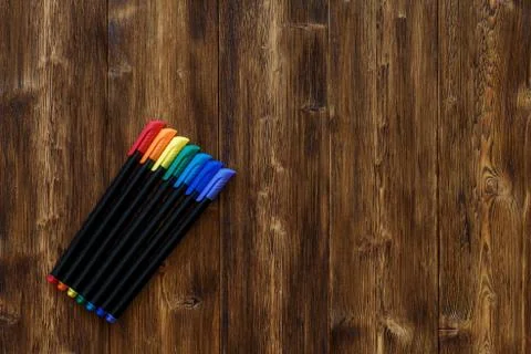 Lots of assorted rainbow colors marker pens, copyspace wooden background Stock Photos