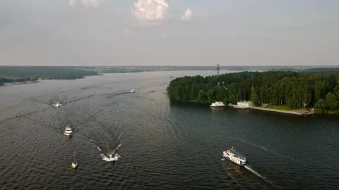 Lots of boats sail through a river during sunset Stock Footage 112155251