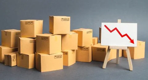 Lots of boxes and an easel with a red down arrow. Slowdown in industrial prod 写真素材