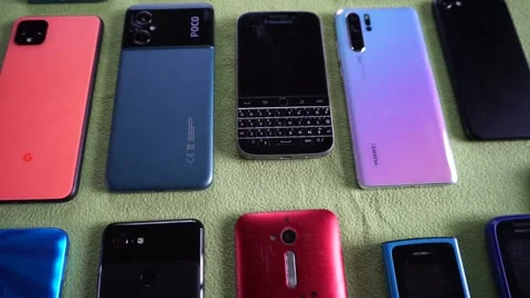 Lots of branded smartphone on green background Stock Footage 321768231