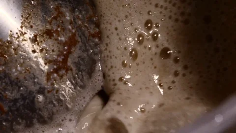 Lots of bubbles in a cocktail. Close-up of mixer whipping milk smoothie with Stock Footage 84022865
