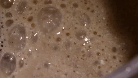 Lots of bubbles in a cocktail. Close-up of mixer whipping milk smoothie with Stock Footage 84022957