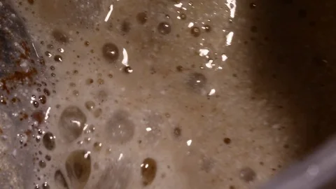 Lots of bubbles in a cocktail. Close-up of mixer whipping milk smoothie with Stock Footage 84023073