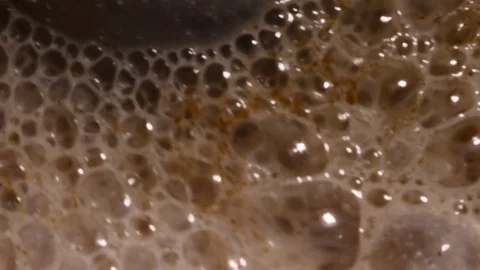 Lots of bubbles in a cocktail. Close-up of mixer whipping milk smoothie with Stock Footage 84023940
