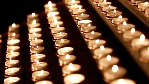 Lots of candles with shallow depth. Small candles on table in Catholic Church. Stock Footage 90915530