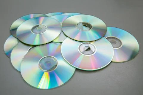 Lots of CDs DVDs on a gray background. Stock Photos