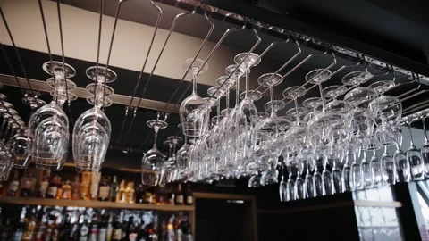 Lots of clean empty wine glasses hanging on a rack in some restaurant. Washed Stock Footage 234546403
