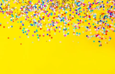 Lots of colored confetti on a yellow background Stock Photos