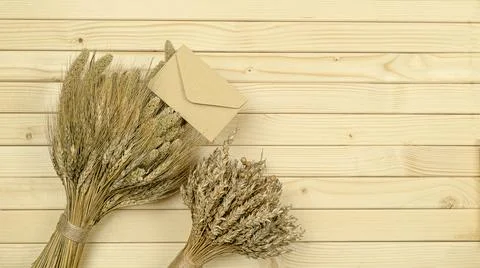 Lots of craft envelopes and a two bouquet of wheat on a wooden background Stock Photos
