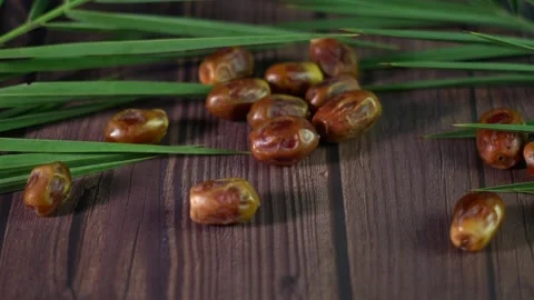 Lots of dates fruit on a wooden table slow motion. Stockbeeldmateriaal 319686685