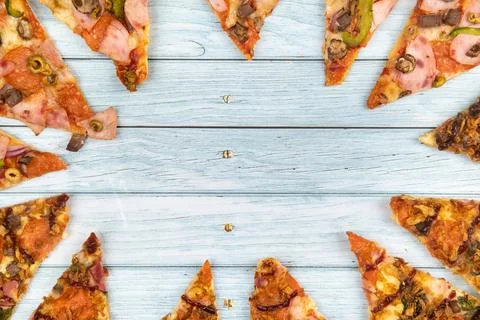 Lots of delicious triangular pizza slices on a blue wooden background Foto stock