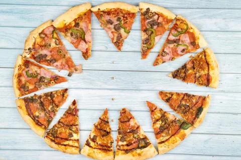 Lots of delicious triangular pizza slices on a blue wooden background Stock Photos
