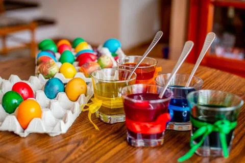 Lots of easter eggs and cups with paint on a wood table. Foto stock