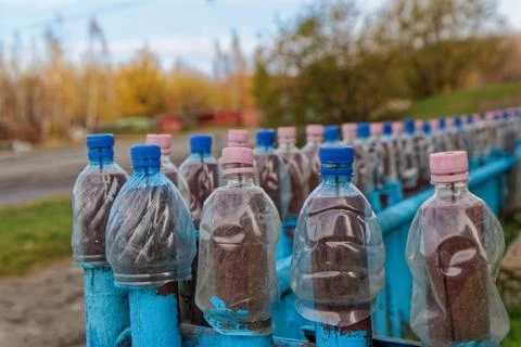 Lots of empty plastic bottles are strung on the fence Stock Photos