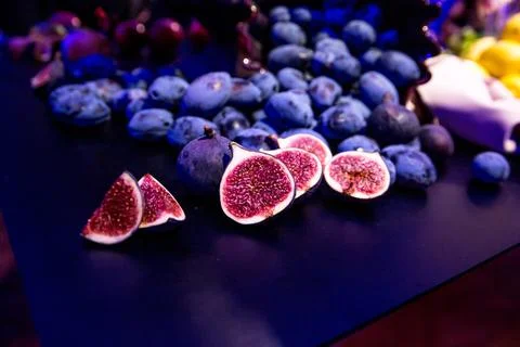 Lots of figs on the black table. Violet Stock Photos